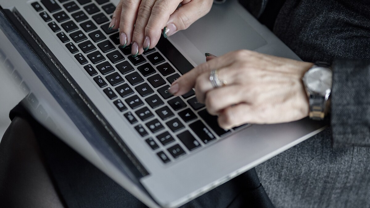 Personne travaillant sur ordinateur pour rechercher un métier en K et des idées d’orientation